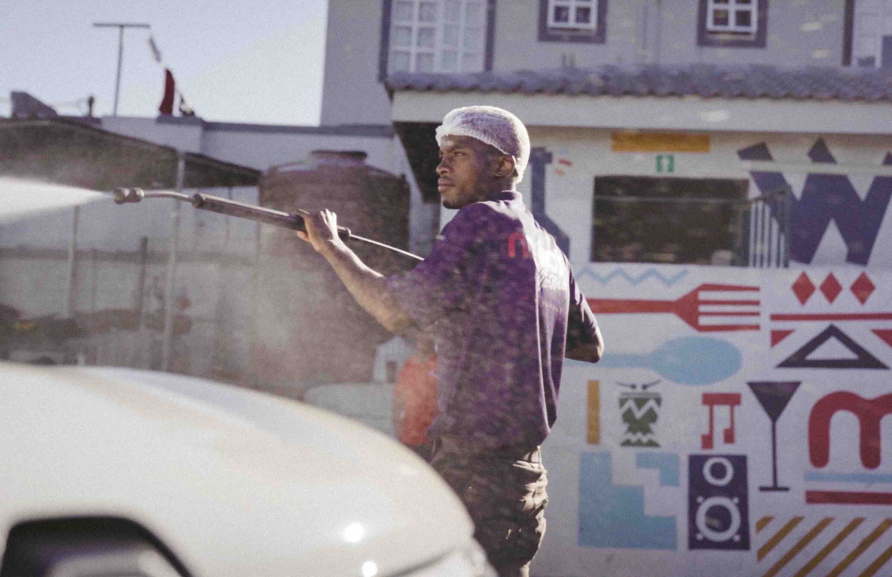man washing a car with a high pressure hose